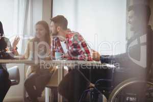 Businessman on wheelchair using digital tablet against photo editors
