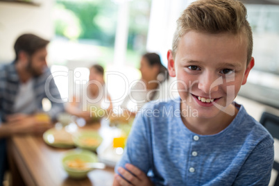 Portrait of boy sitting on dining table