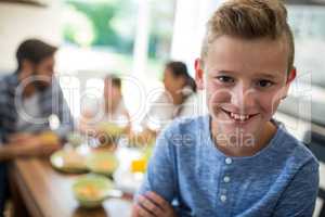 Portrait of boy sitting on dining table