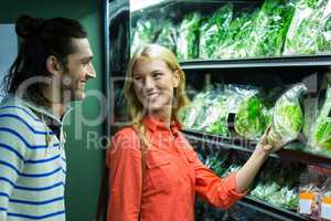 Happy couple selecting vegetables in organic section