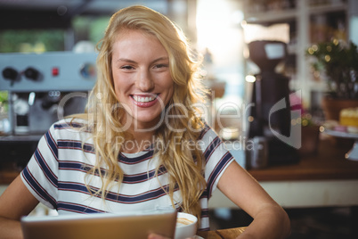 Woman sitting in a cafe using digital tablet