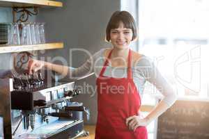 Smiling waitress standing with hand on hip at cafÃ?Â©