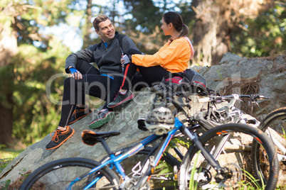 Biker couple interacting with each other in forest