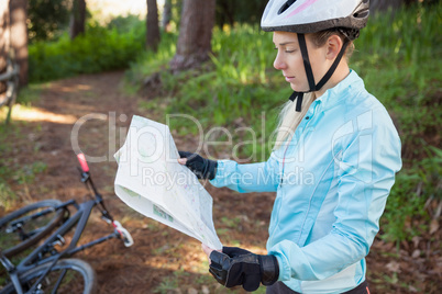 Female mountain biker looking at map