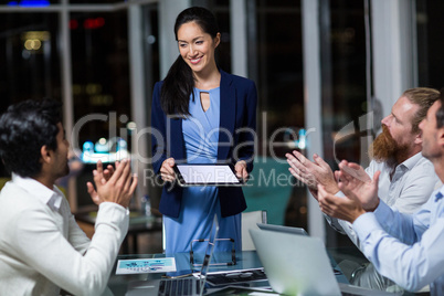 Coworkers applauding a colleague after presentation Coworkers applauding a colleague after presentation