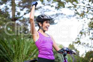 Female cyclist standing with mountain bike in park