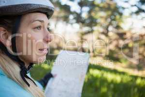 Female mountain biker holding map