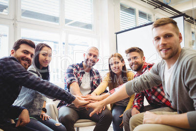 Portrait of smiling creative business people stacking hands