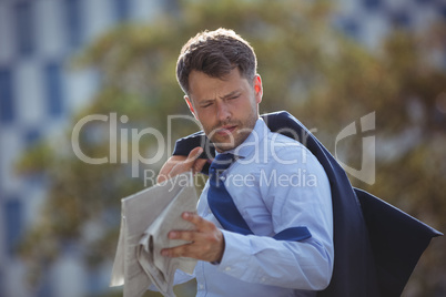 Handsome businessman reading newspaper