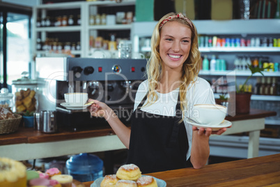 Smiling waitress offering cup of coffee