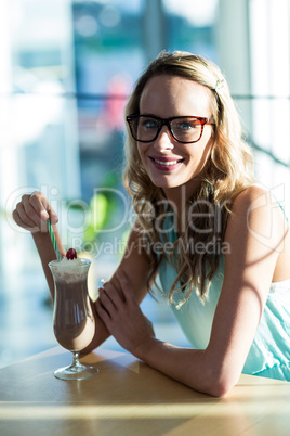 Portrait of woman drinking milkshake with a straw