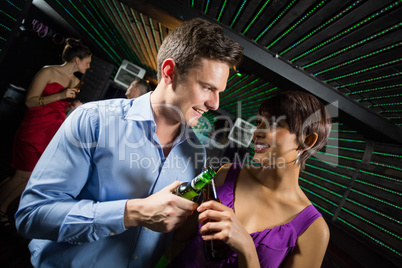 Happy couple toasting a beer bottles