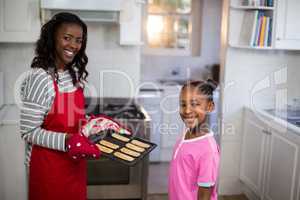 Mother and daughter with a baking tray