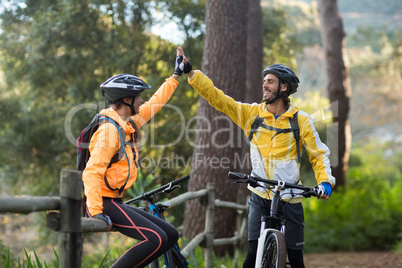 Biker couple giving high five to each other in countryside