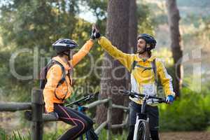 Biker couple giving high five to each other in countryside