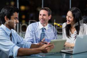 Businessman discussing with colleagues over digital tablet