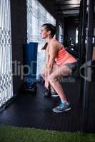 Full length of female athlete holding kettlebell in gym