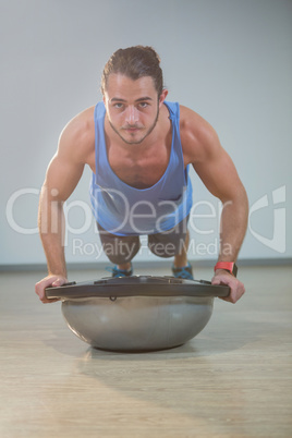 Man doing push-up on bosuball