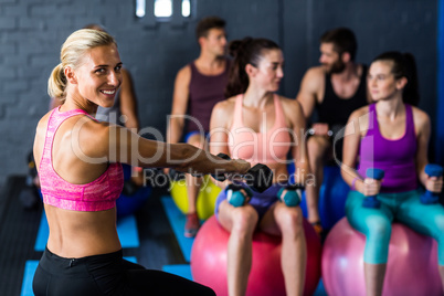 Happy trainer with athletes in gym