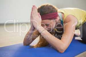 Woman performing yoga on exercise mat