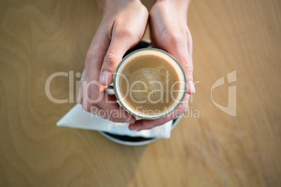 Hands holding a coffee cup