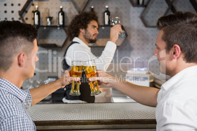 Two men toasting a glass of beer