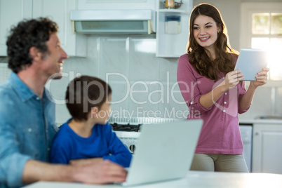 Family using digital tablet and laptop