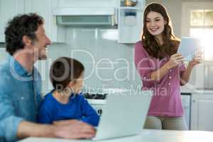 Family using digital tablet and laptop