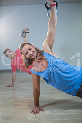 Men exercising with kettlebell