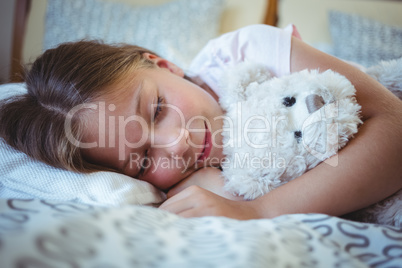 Girl lying with a teddy bear