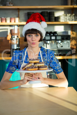 Waitress holding a tray of doughnuts