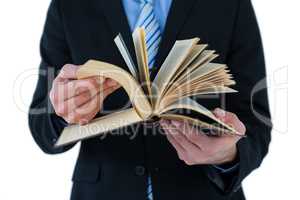 Mid section of businessman flips through the pages of a book