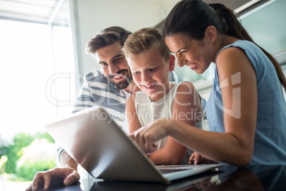 Happy family using laptop in the living room