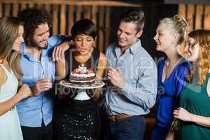 Woman blowing the candle on her birthday cake