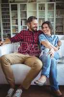 Happy couple sitting on sofa in living room