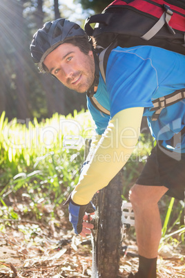 Portrait of male mountain biker fixing his bike chain