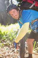 Portrait of male mountain biker fixing his bike chain