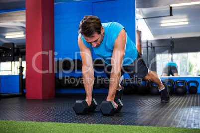 Young man with dumbbells in gym