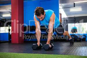 Young man with dumbbells in gym