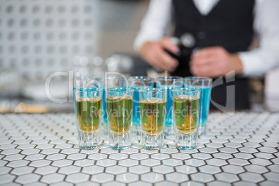 Glass of blue lagoon drinks and whisky on bar counter