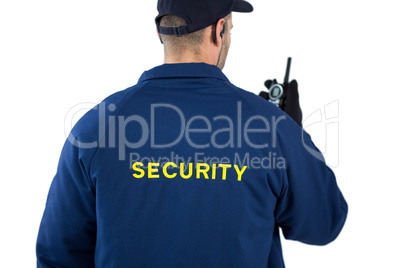 Rear view of security officer talking on walkie-talkie