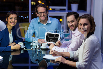 Businessman discussing work on digital tablet with colleagues