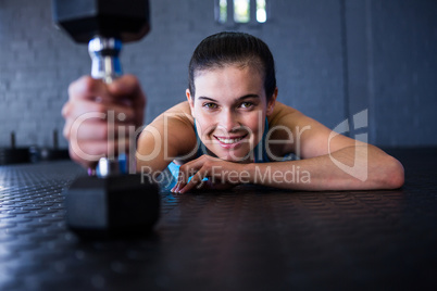 Happy female athlete holding dumbbell