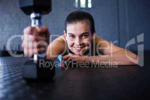 Happy female athlete holding dumbbell