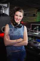 Pretty female DJ standing with arms crossed