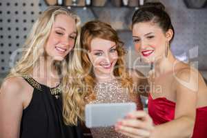 Smiling friends taking a selfie from mobile phone