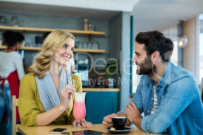 Couple interacting while having a cup of coffee and milkshake