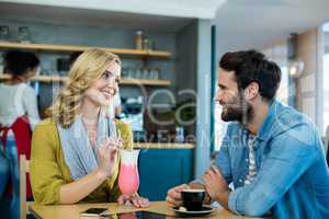 Couple interacting while having a cup of coffee and milkshake