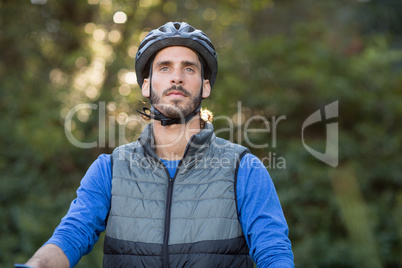 Thoughtful male biker in forest