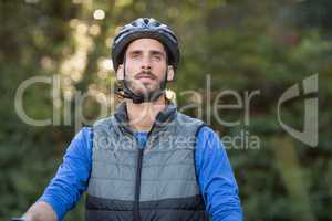 Thoughtful male biker in forest